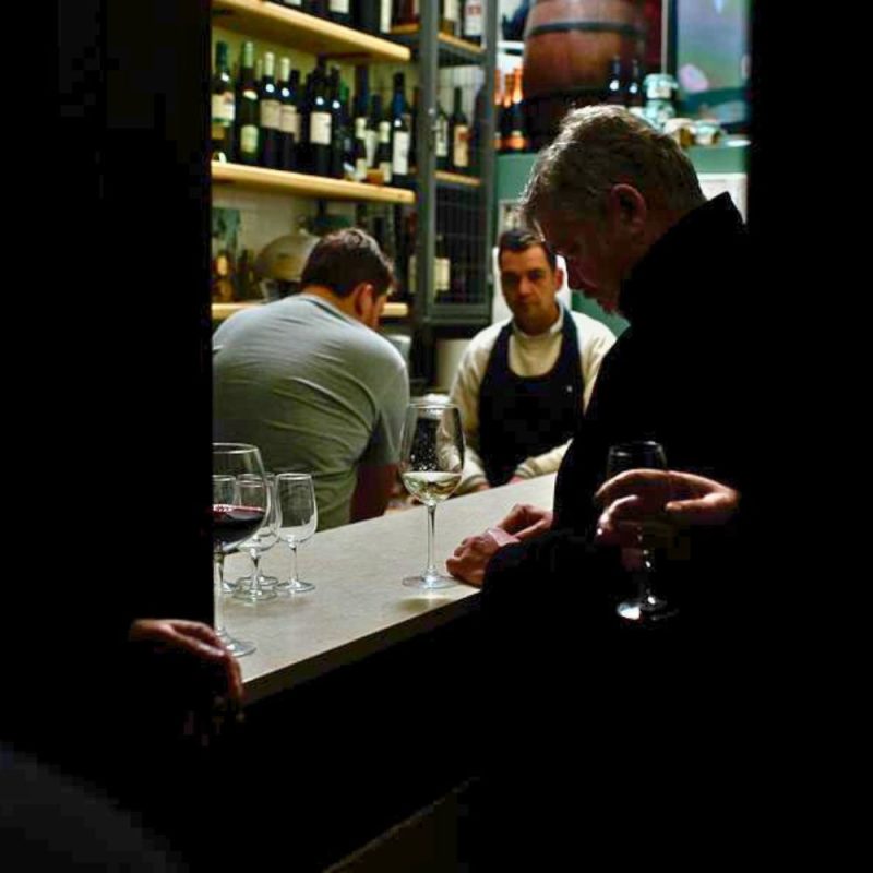 Guests and staff interacting at the Cinque Wine & Deli bar during an intimate wine service moment, highlighting hands-on learning and hospitality experience.