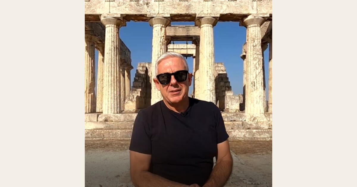 Man standing in front of an ancient Greek monument, symbolizing cultural authenticity and meaningful travel experiences in Greece.