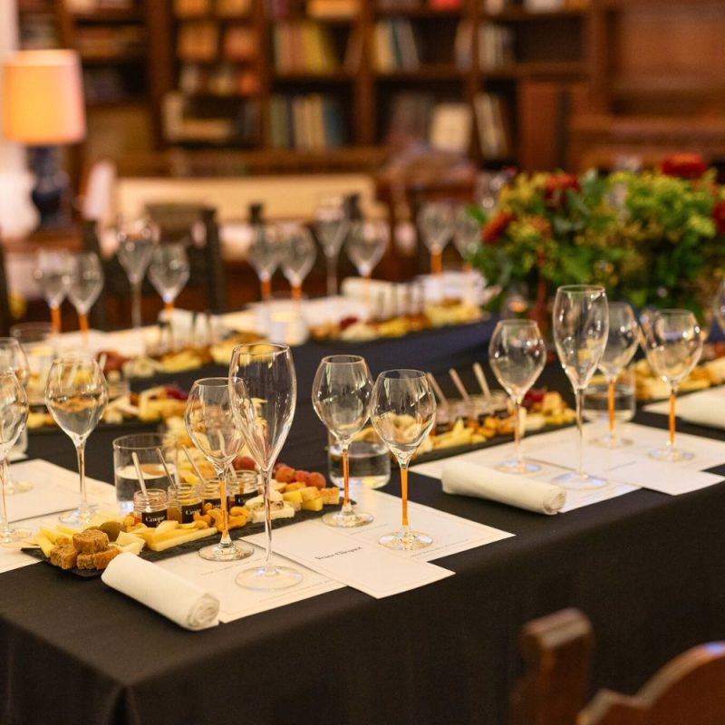 Champagne tasting table with Veuve Clicquot glasses and Greek cheese platters prepared by Cinque for a luxury pairing event.