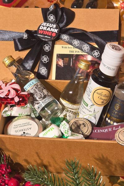 Cinque Gift Box with Jesus Drank Wine T-shirt, Greek sweets, and a founders’ photo, presented in festive packaging.