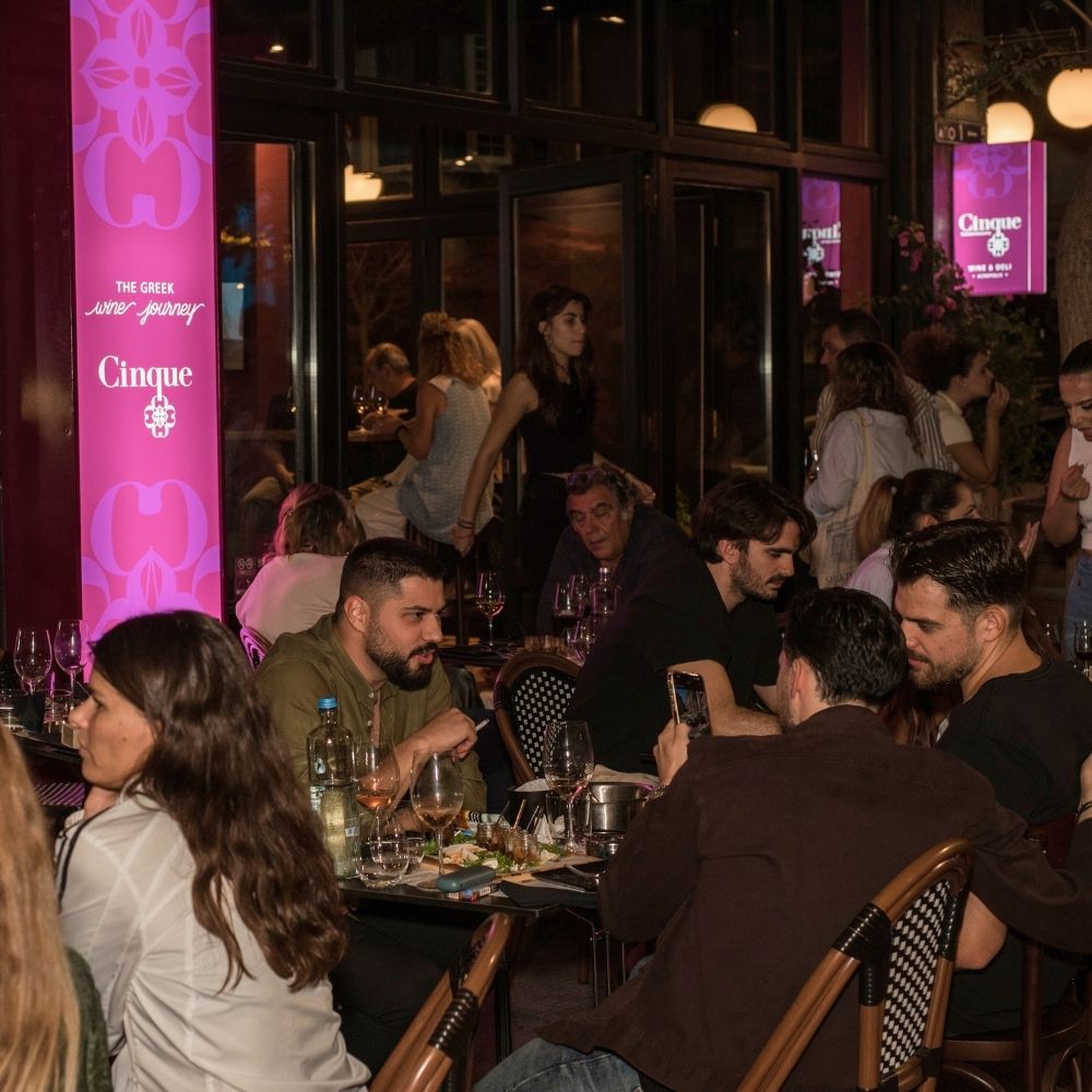 Guests enjoying wine and food at Cinque Urban all-day wine and deli concept in a vibrant city setting.