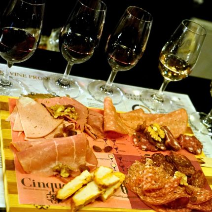 Greek wine and charcuterie tasting with assorted cured meats and wine glasses at Cinque Wine & Deli