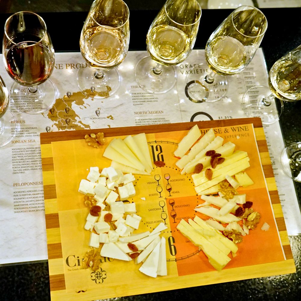Greek cheese clock tasting with eight cheeses and eight wine glasses paired with Greek wines at Cinque Wine & Deli