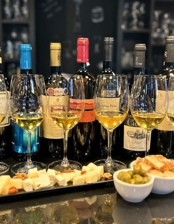 Emblematic Greek wine tasting with seven wine glasses, Greek cheeses and olives at Cinque Wine & Deli