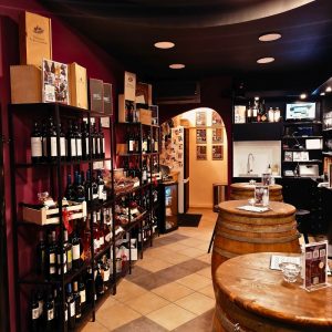 Cinque maroussi interior with wine shelves and barrel tables reflecting everyday urban wine culture in Athens