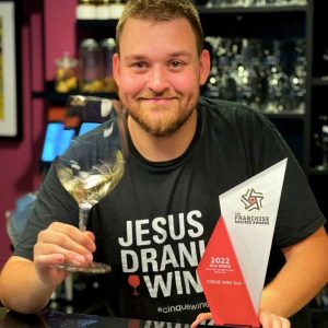 Cinque Wine Bar founder holding the Gold Award for Franchise Business Model Innovation 2022, highlighting an award-winning Greek wine bar franchise concept built on authentic hospitality and scalability.