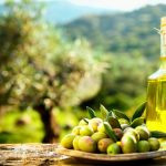 Fresh Greek olives and extra virgin olive oil bottle in an olive grove at Cinque Casa