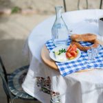 Traditional Greek meze with bread, feta, tomato and tsipouro served on a small table in the garden of Casa Cinque
