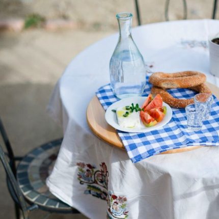 Traditional Greek meze with bread, feta, tomato and tsipouro served on a small table in the garden of Casa Cinque