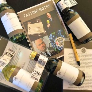 Cinque virtual wine tasting kit with small-format wine bottles, tasting notes and branded materials prepared for an online wine experience.