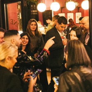 Cinque Wine Bar tasting event with guests and host actively engaging in wine discussion, illustrating hands-on involvement and hospitality culture within the franchise network.