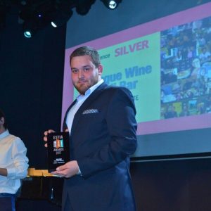 Nikitas Prassas holding the Silver Award at the ESTIA Awards 2017 for Cinque Wine & Deli wine bar experience in Athens.