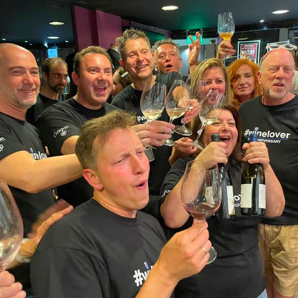 Team-bonding wine experience at Cinque Wine & Deli with a group raising glasses and celebrating together