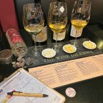 Wine and cheese tasting with three wines and Greek cheeses presented on a stone platter at Cinque Wine & Deli