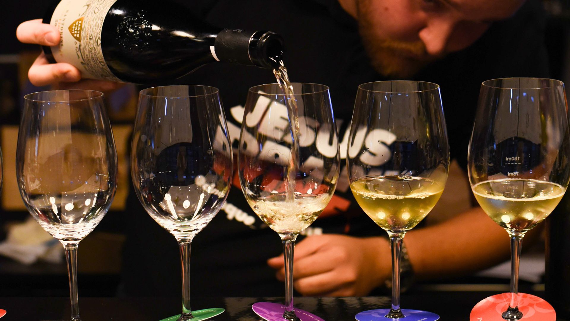 Wine tasting experience at Cinque Wine & Deli, with a sommelier pouring Greek wine into tasting glasses during a guided tasting session.