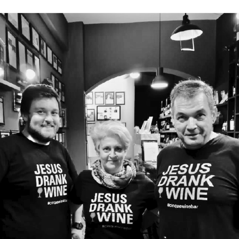 Cinque Wine & Deli team members wearing “Jesus Drank Wine” shirts inside the Athens wine bar.