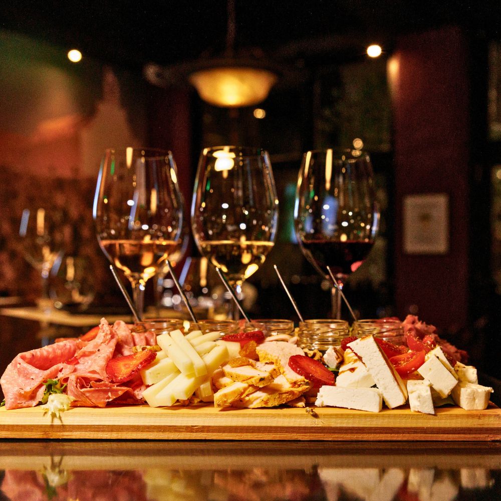 Greek wine tasting flight with red and white wines paired with cheeses and charcuterie at Cinque Wine & Deli Athens.