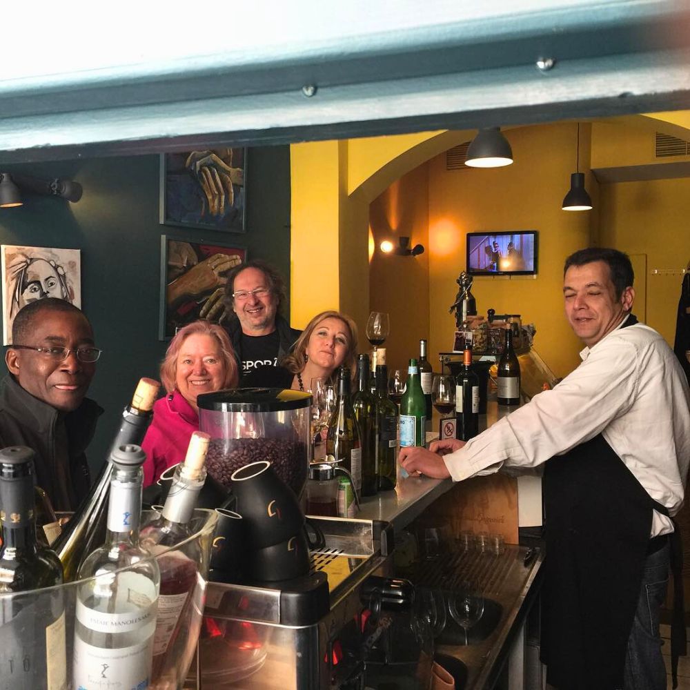 International wine lovers with Cinque team at wine bar in Psyrri Athens enjoying Greek bottled wines.