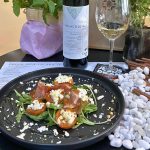 Grilled apricots with goat cheese, Greek cured meat and greens paired with Malagousia white wine at Cinque Athens.