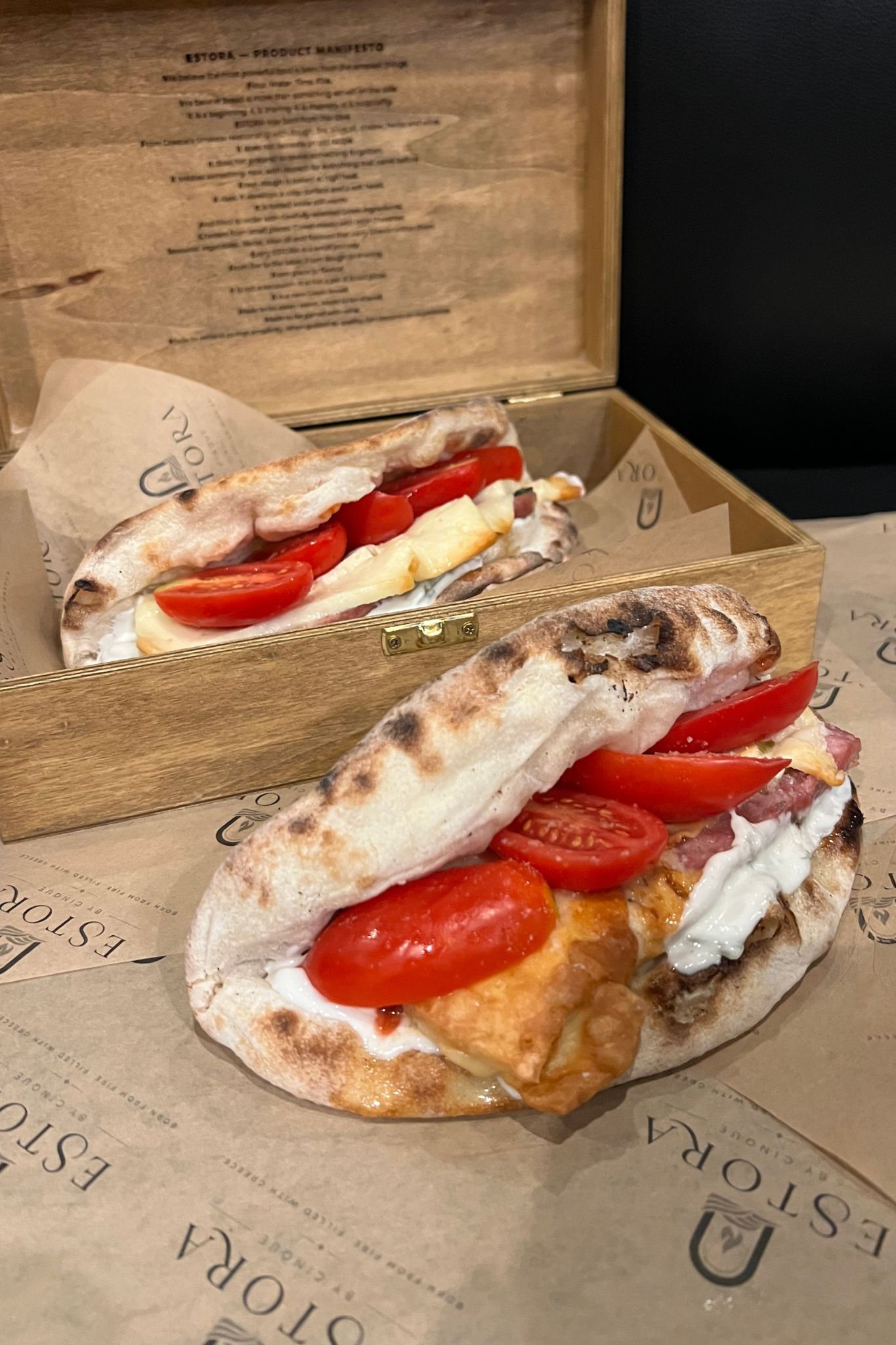ESTORA Greek bread with pork sausage, grilled kefalotyri, handmade tzatziki and cherry tomatoes