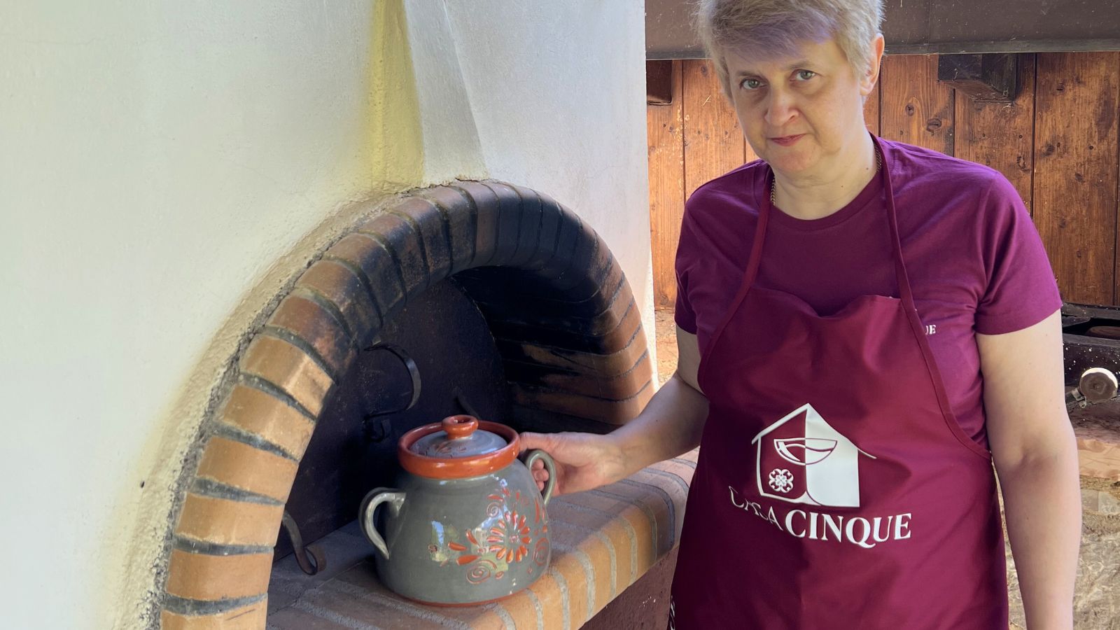 Evangelia beside the wood-fired oven at Casa Cinque