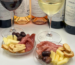 Glasses of white and red Cinque Selection wine with small plates of cheese, cured meats, olives and rusks for Aperivino.