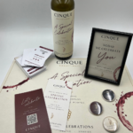 Cinque Celebrations setup with Greek wine, personalised celebration bottle, Wine Quest cards, pins and keepsake frame at Cinque Monastiraki