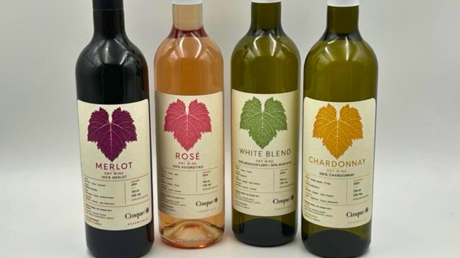 Four Cinque Essentials wine bottles: Merlot, Rosé, White Blend and Chardonnay, with coloured vine leaves and information on their labels.