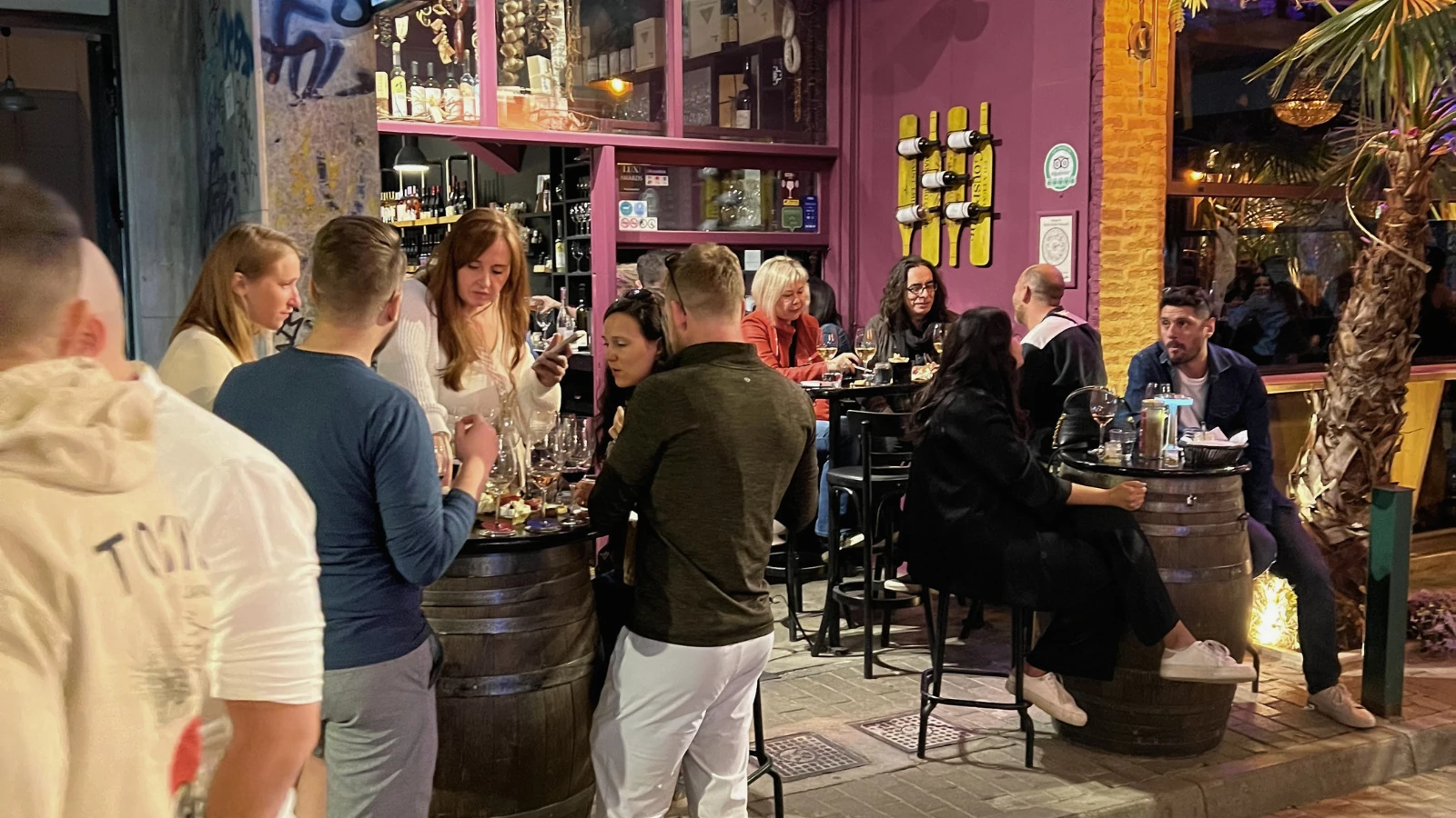 Guests sharing wine at outdoor barrel tables at Cinque Wine Bar Psirri, Athens
